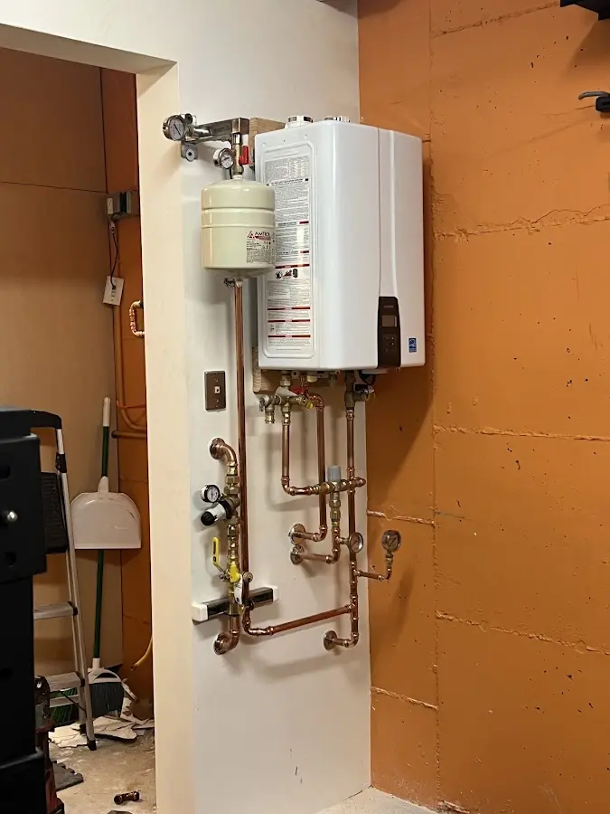 Plumbing technician inspecting water heater connections in Windber